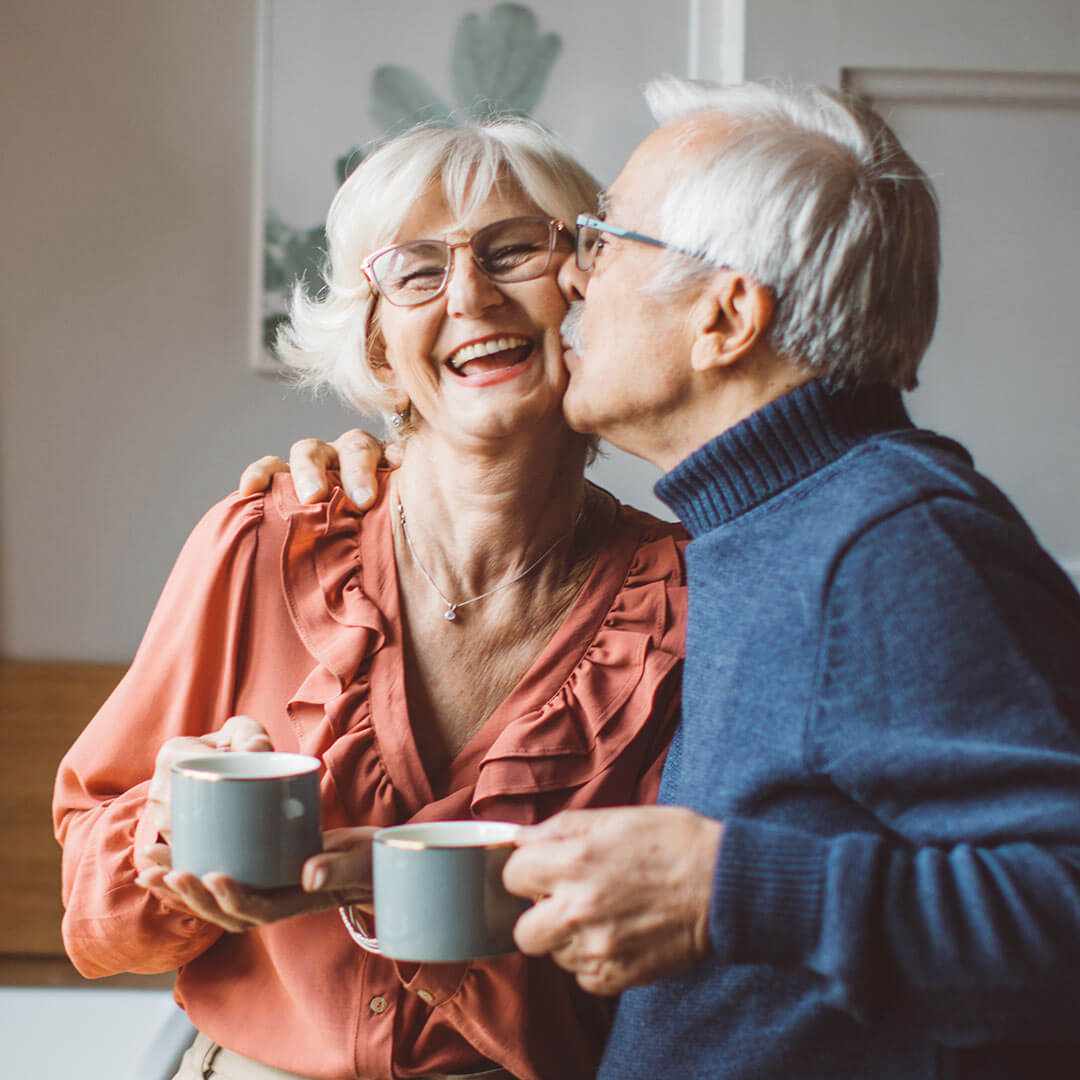 Older couple with mugs embracing