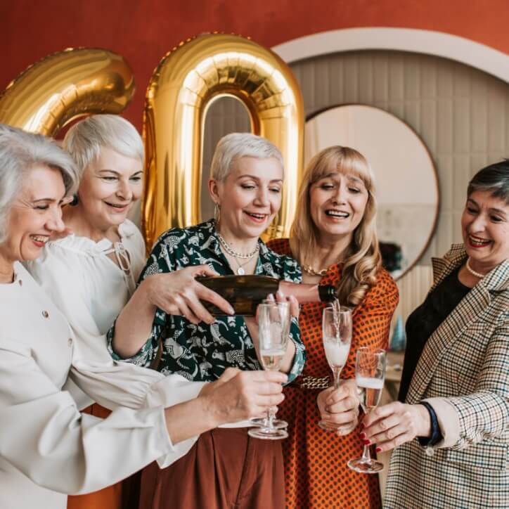 Older women pouring champagne into glasses